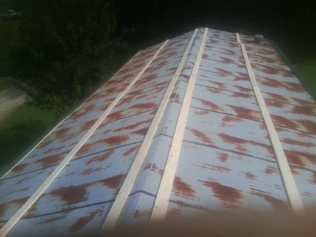 Rusted metal roof panels with new wood purlins before replacement — Storm Damage Roof Repair in West Sayville by Roofing Brothers