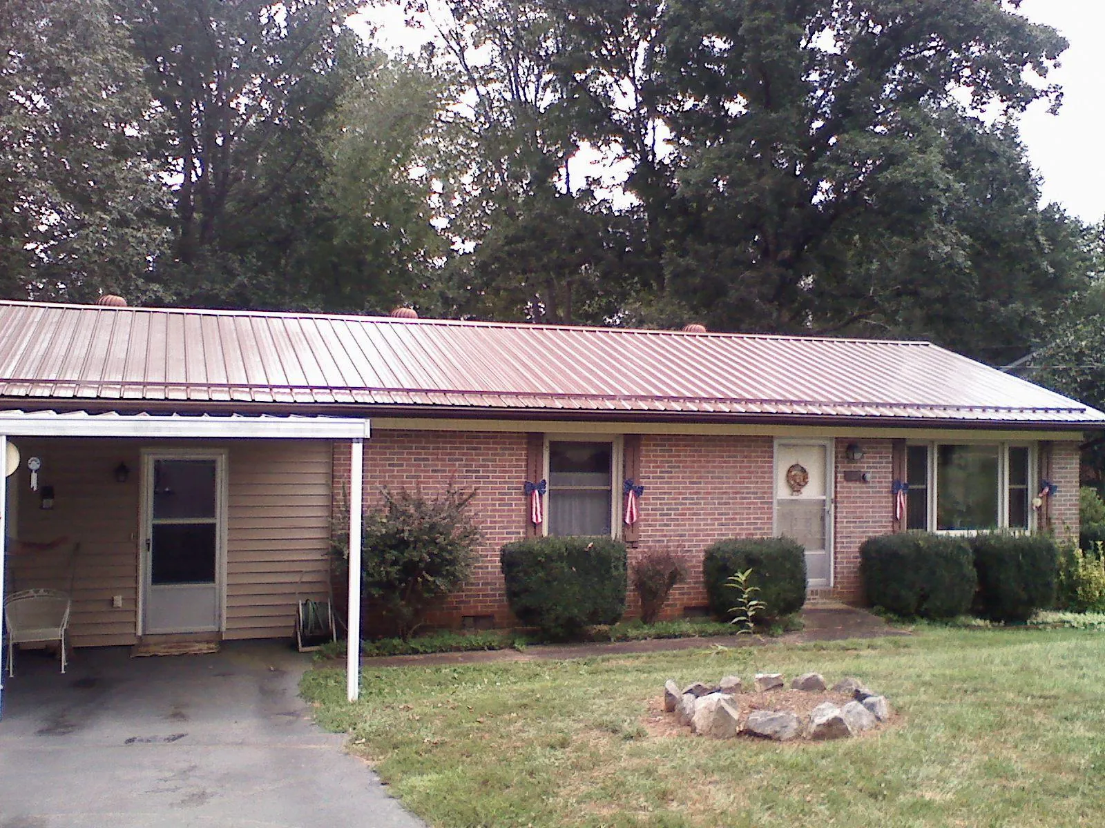 Bronze metal roof and carport on a brick ranch home — Roof Repair work by our crew in West Sayville